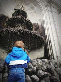 Rear view of boy against waterfall