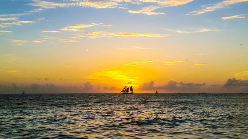 Boat sailing in sea at sunset