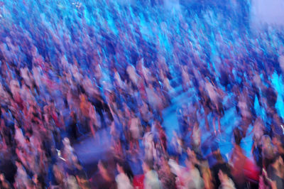 Defocused image of people enjoying at music concert