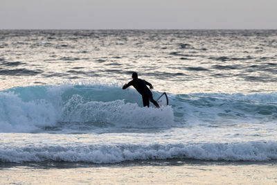Man on bird at beach against sky