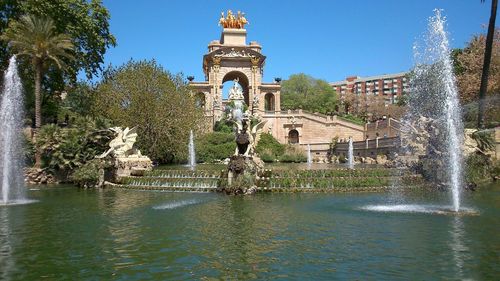 Fountain in city against clear sky