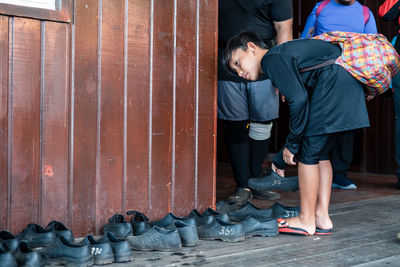 Full length of boy wearing shoes while standing on floor