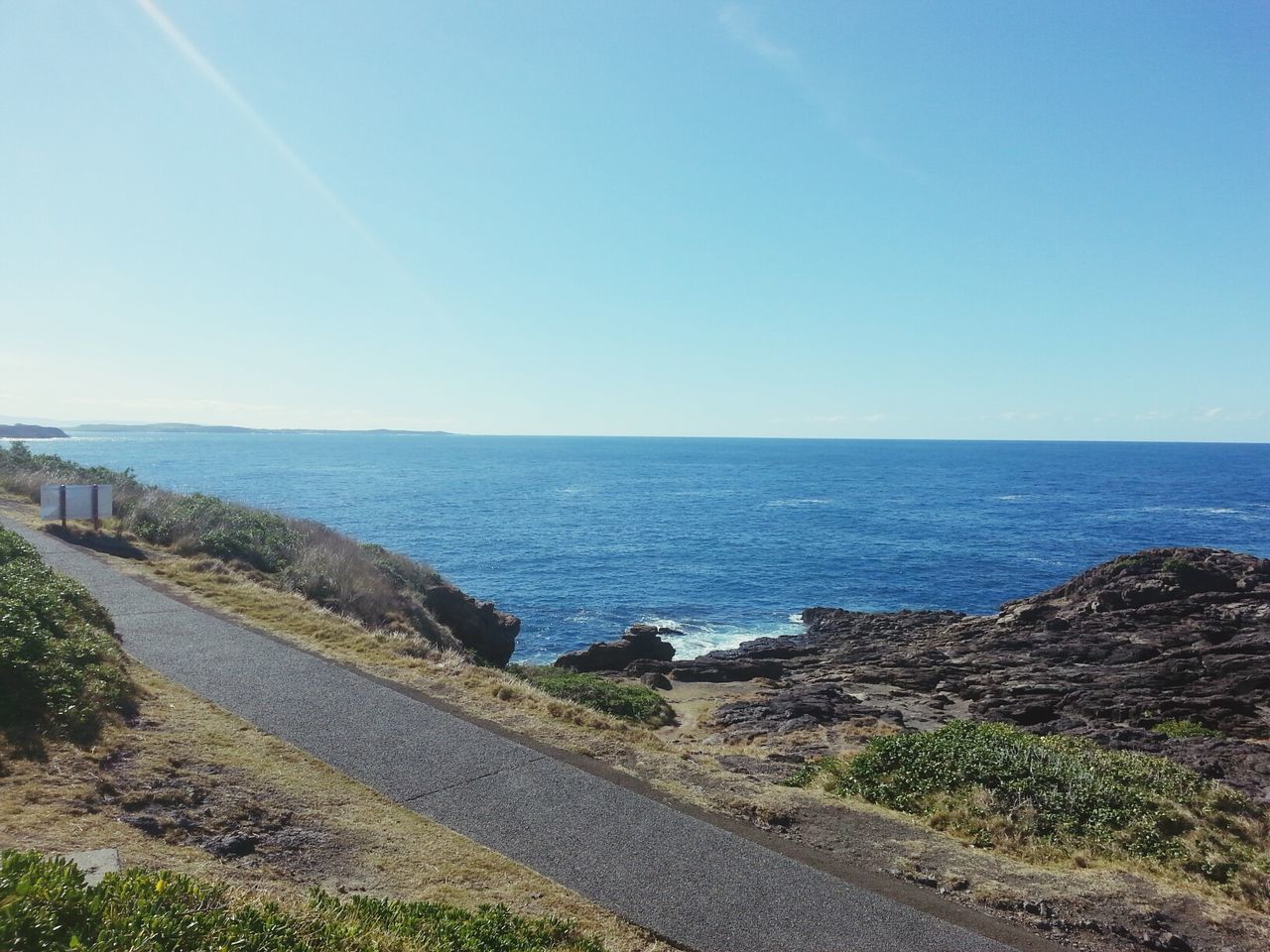 ROAD BY SEA AGAINST CLEAR BLUE SKY