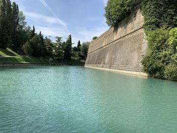 Scenic view of swimming pool by river against sky