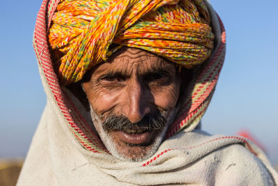Close-up portrait of man wearing turban against clear sky