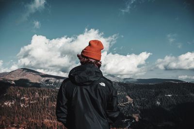 Rear view of man looking at mountain against sky