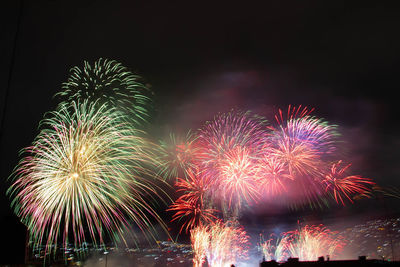 Low angle view of firework display at night