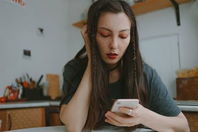 Young beautiful woman with the smartphone at home
