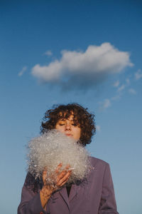 Woman with plastic against blue sky