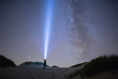 Full length of woman standing against sky at night