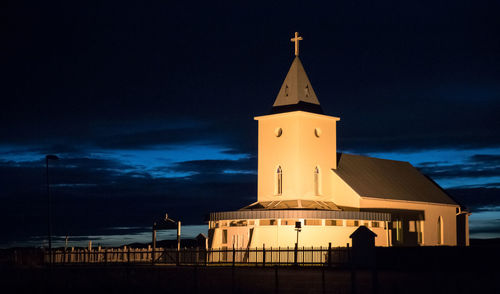 Illuminated building against sky at night