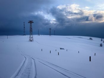 Transmission towers in the mountains during winter on a cloudy day