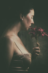 Portrait of beautiful woman smelling a bouquet of lilies vi