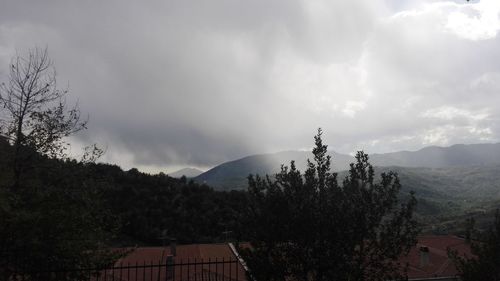 Panoramic view of trees and mountains against sky
