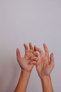 Close-up of hands over white background