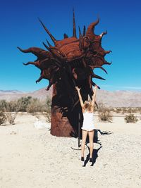 Full length of man standing on desert against clear sky