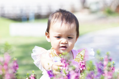 Portrait of cute girl against white flowering plants