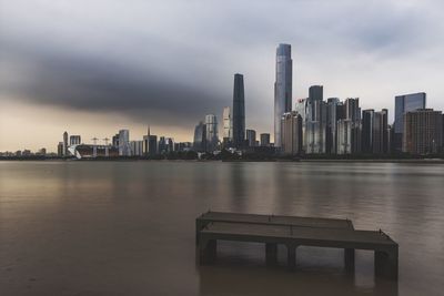 Sea by cityscape against sky