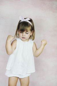 Cute girl standing against wall