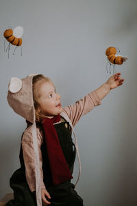 Low angle view of girl with balloons against white background