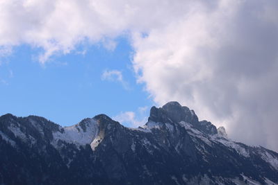 Low angle view of snowcapped mountains against sky