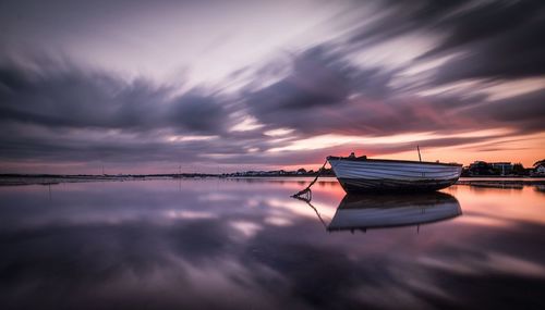 Boats in sea at sunset