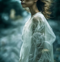 Portrait of young woman standing in park