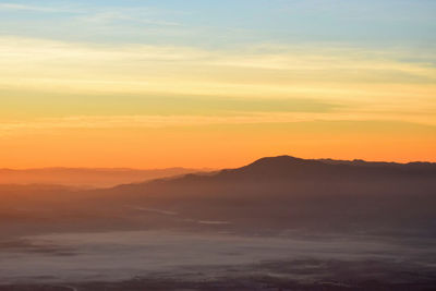 Scenic view of silhouette mountain against romantic sky at sunset