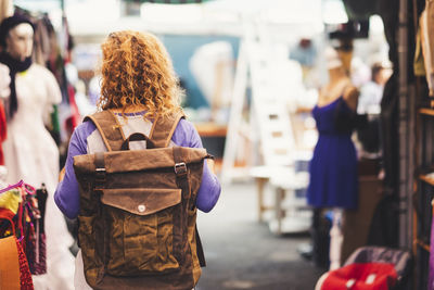 Rear view of woman with backpack standing at market