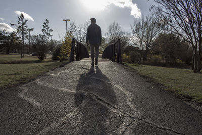 Rear view of man in park against sky