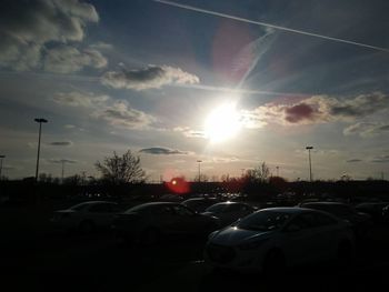 Cars on road against sky during sunset