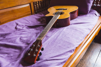 High angle view of playing guitar on bed