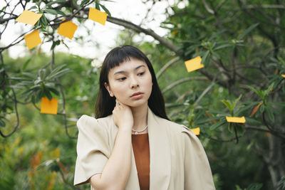 Portrait of woman standing against plants