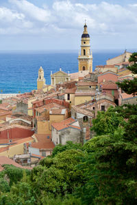 High angle view of townscape by sea against sky