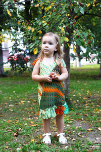 Full length of girl standing against tree