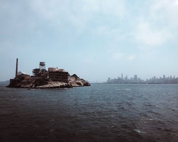 View of buildings by sea against sky