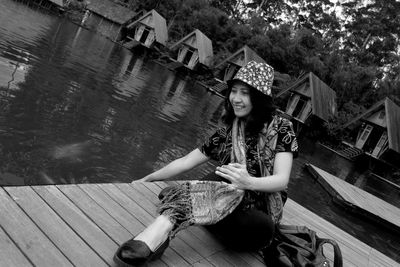 Full length of woman sitting on pier