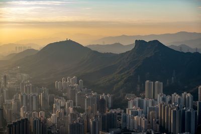 Aerial view of buildings in city at sunset