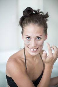 Young woman using face mask