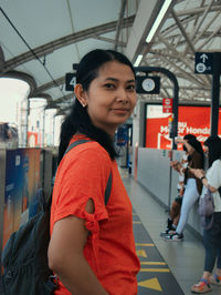 Portrait of young woman standing in city