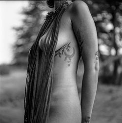 Midsection of naked woman standing outdoors