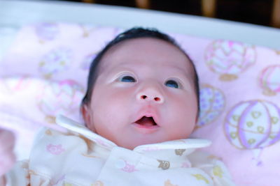 Portrait of cute baby lying on bed