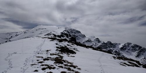 Scenic view of snow covered mountains against sky