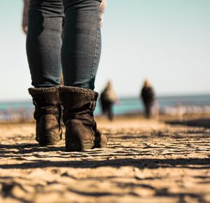 Low section of man standing on beach