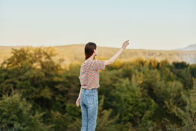 Rear view of woman standing on field