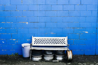 Empty bench against blue wall