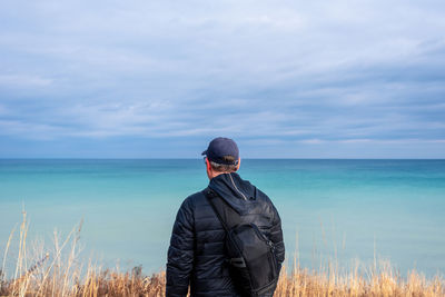 Man standing by sea against sky