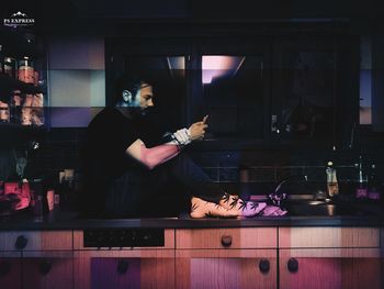 Man using mobile phone while sitting on table