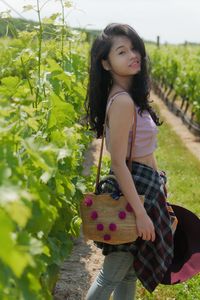 Happy girl standing by plants in basket