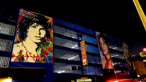 Low angle view of illuminated text on building at night